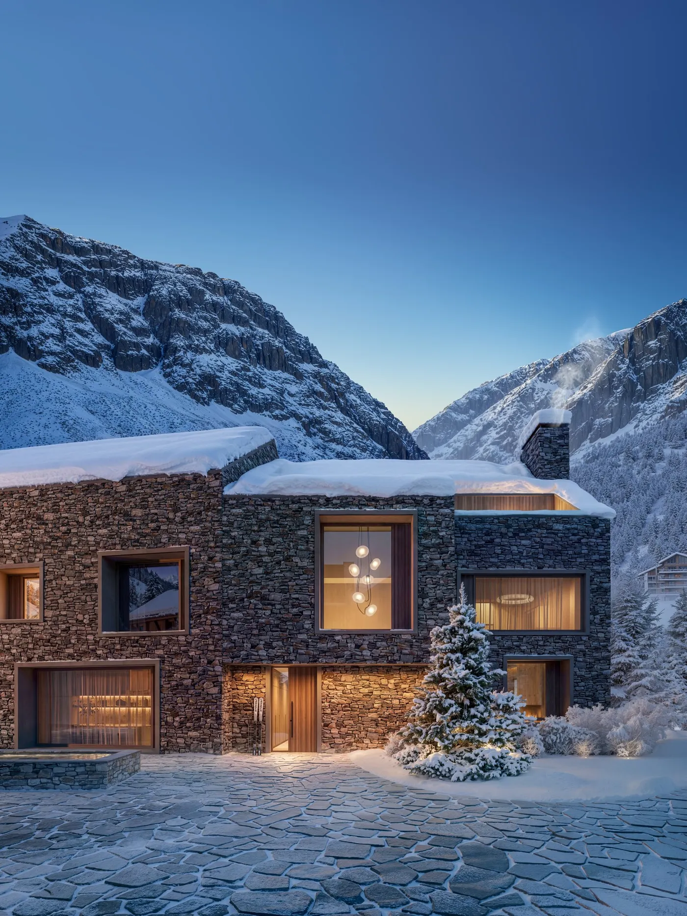 Stone-clad villa courtyard at dusk, lit windows against snow-covered peaks